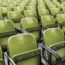 Full frame shot of empty green chairs at stadium