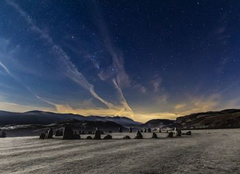 Scenic view of a stone circle in a mountainous landscape against sky at night