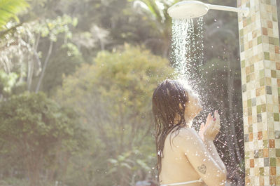 Rear view of woman standing in water