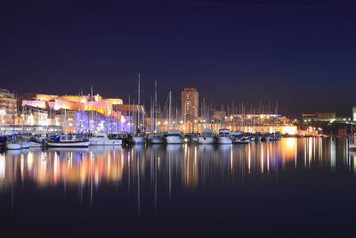 Boats moored in harbor at night