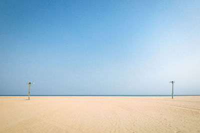 Scenic view of beach against clear blue sky
