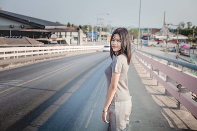 Portrait of young woman on road in city