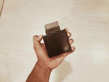 Close-up of person holding camera on table