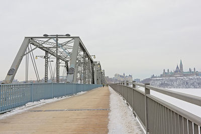 Bridge over river in city against sky