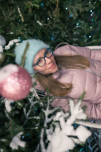 Portrait of young woman with christmas tree
