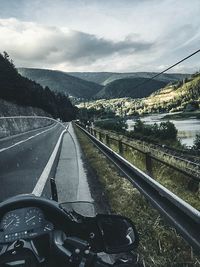 Cars on road against sky seen through car windshield