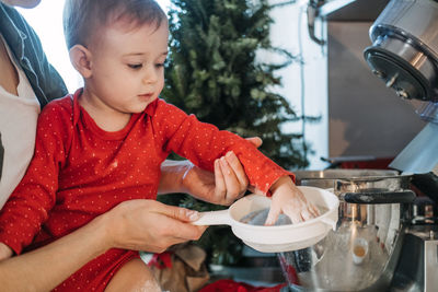 Cozy christmas at home. family preparation holiday dessert. mother and baby toddler daughter play