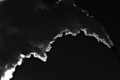 Low angle view of smoke emitting from silhouette at night