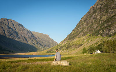 Rear view of man on mountain against sky