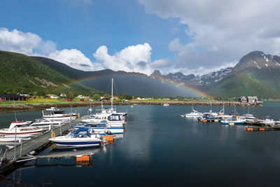 Boats moored at harbor against sky