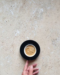 Directly above shot of hand holding coffee cup