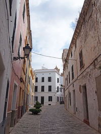 Narrow street amidst buildings against sky