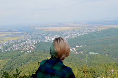 Rear view of woman looking at landscape against sky