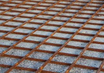 Full frame shot of rusty metal grate on footpath