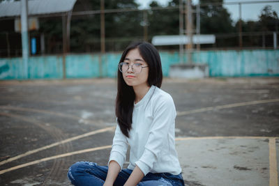 Young woman sitting on basketball court