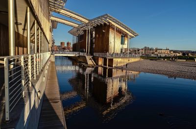 Bridge over river amidst buildings against sky
