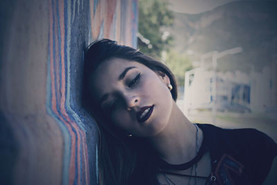 Close-up of thoughtful young woman by wall