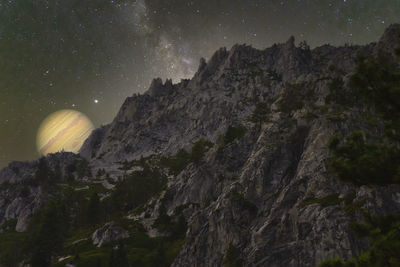 Low angle view of rock formation against sky at night