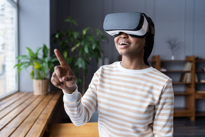 Joyful woman in virtual reality glasses headset touching vr screen use modern augmented technology