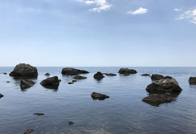 Scenic view of rocks in sea against sky