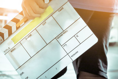 Close-up of man holding clapper board