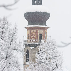 Built structure on snow covered tree against sky