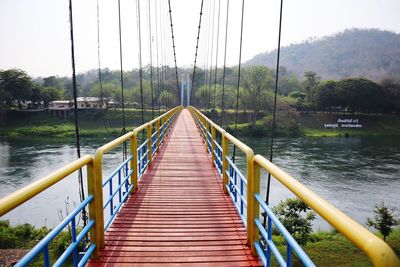 Footbridge over river against sky