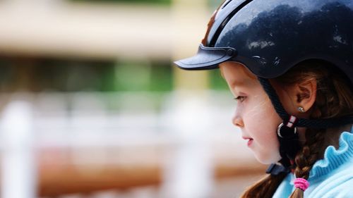 Close-up of girl wearing helmet outdoors