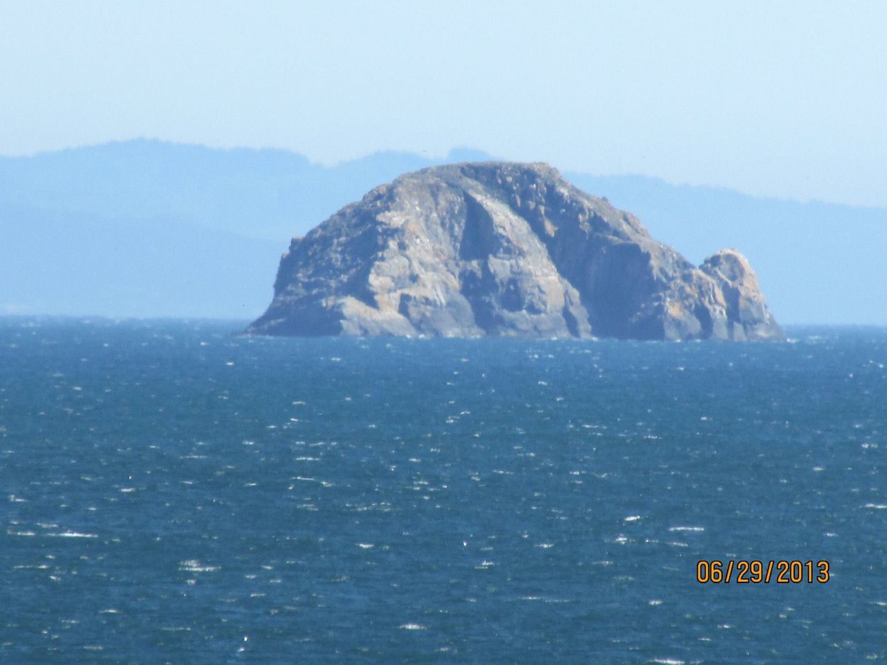 SCENIC VIEW OF SEA WITH MOUNTAIN IN BACKGROUND