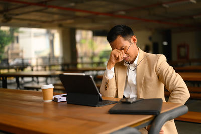 Young woman using laptop while sitting at cafe