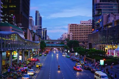 City street and buildings against sky at dusk