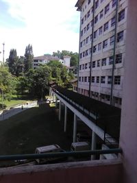 Bridge by buildings in city against sky