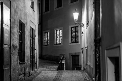 View of alley amidst buildings at night in prague