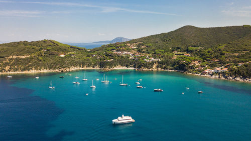 Aerial view of turqoise shore line with many yachts