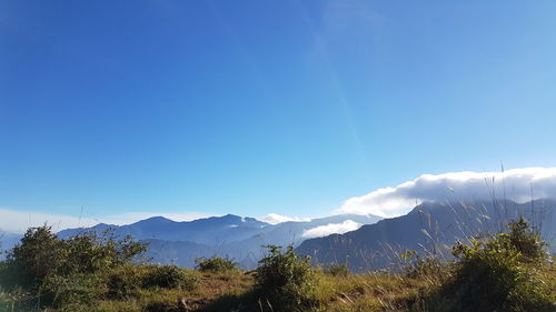 Scenic view of mountains against blue sky