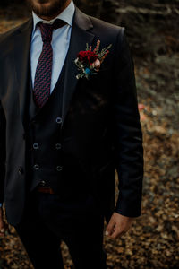 Midsection of bridegroom standing outdoors