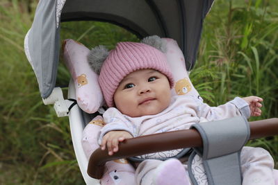 Portrait of cute daughter sitting on grass