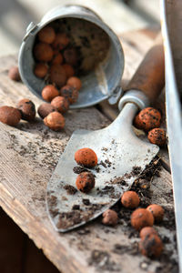 Closeup on clay balls and dirt in a shovel put on a wooden table for potted