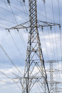 Low angle view of electricity pylon against sky