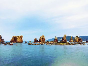 Rocks in sea against sky