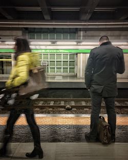 Rear view of men on railroad station platform