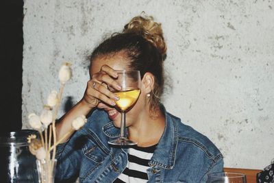 Smiling young woman holding glass in restaurant