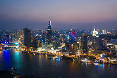 Illuminated buildings in city against sky at night