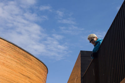 Low angle view of woman against blue sky