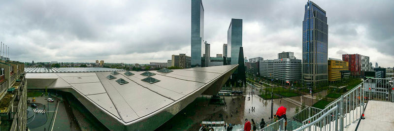 Buildings in city against cloudy sky