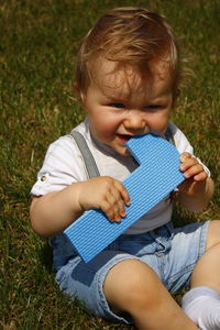 Boy holding book on field