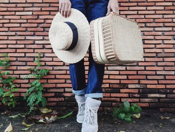 Low section of man standing against brick wall