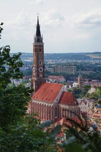 View of town by buildings and chuch against sky