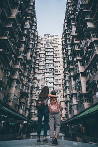 Rear view of women walking on street in city