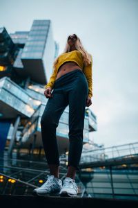 Full length of woman standing against sky in city